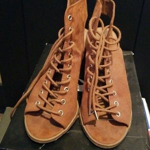 Lace up, open toe booties in a cognac color.